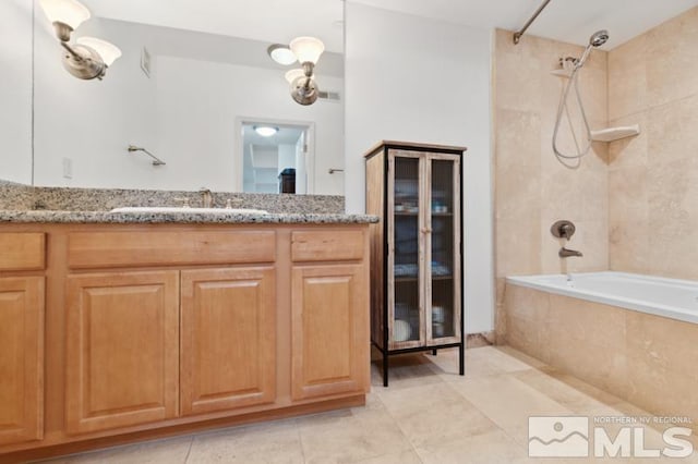 bathroom featuring tile floors, tiled shower / bath combo, and vanity