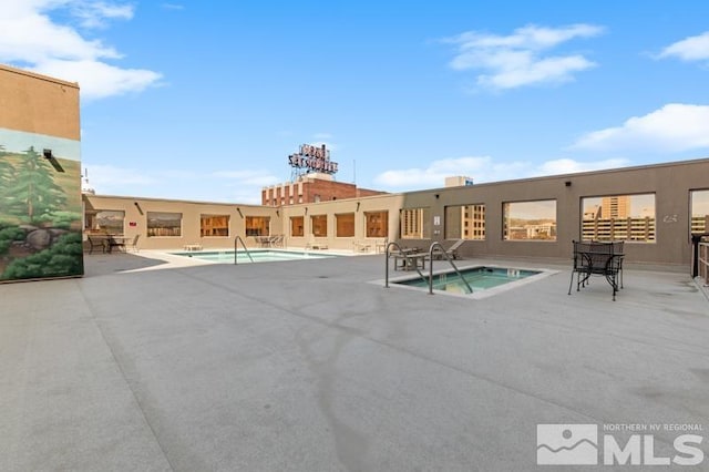 view of pool featuring a hot tub and a patio