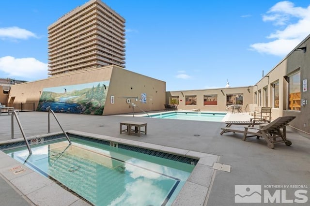 view of pool with a hot tub and a patio