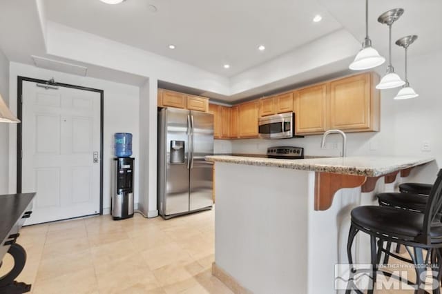 kitchen featuring stainless steel appliances, a tray ceiling, light stone countertops, light tile floors, and pendant lighting