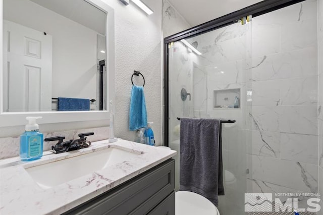 bathroom with walk in shower, oversized vanity, and toilet