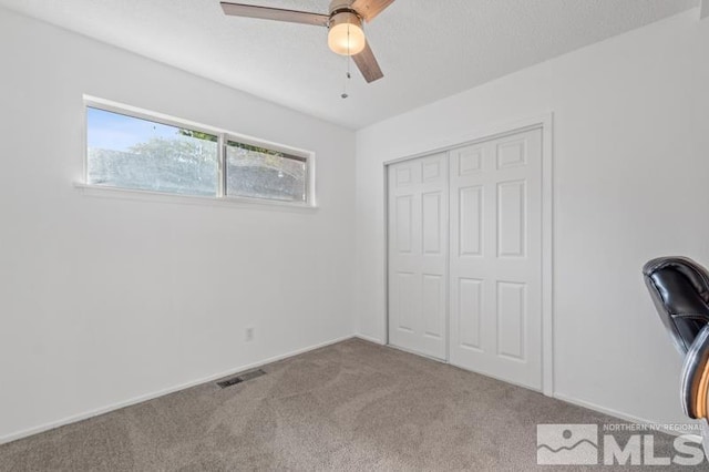 unfurnished bedroom with a closet, ceiling fan, and carpet floors