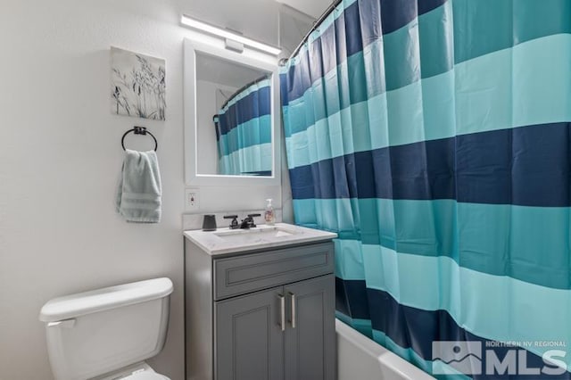 full bathroom featuring toilet, large vanity, and shower / bathtub combination with curtain