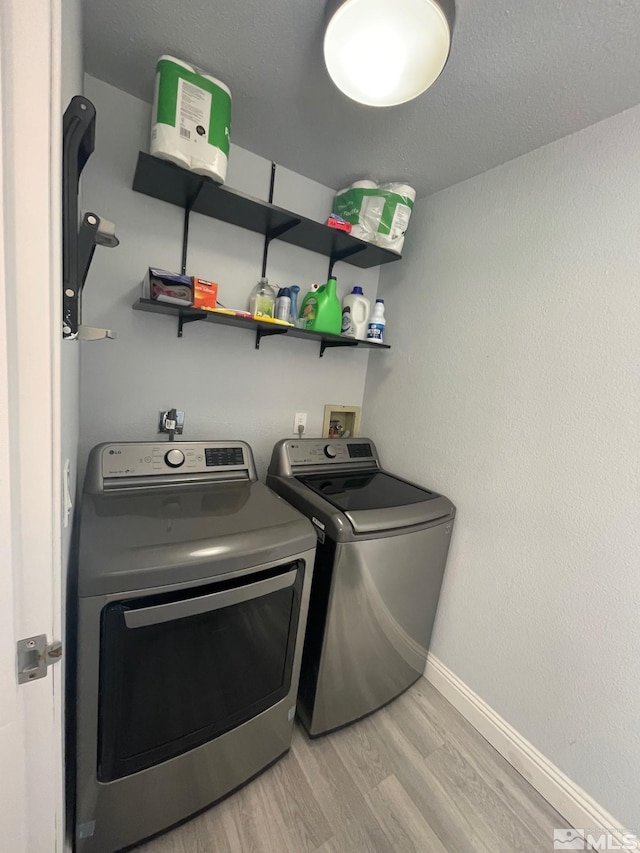 laundry area with separate washer and dryer, light hardwood / wood-style flooring, and washer hookup