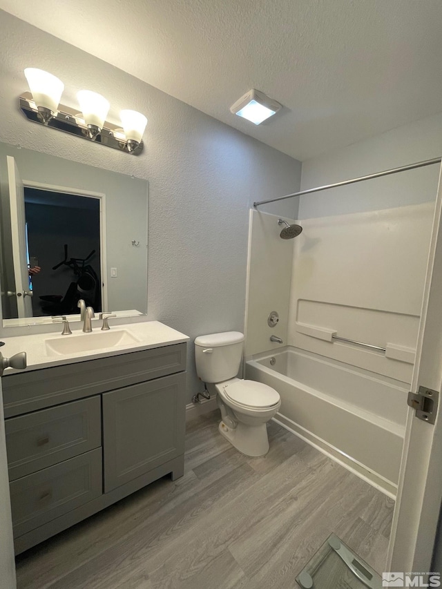 full bathroom with hardwood / wood-style flooring,  shower combination, vanity, and toilet