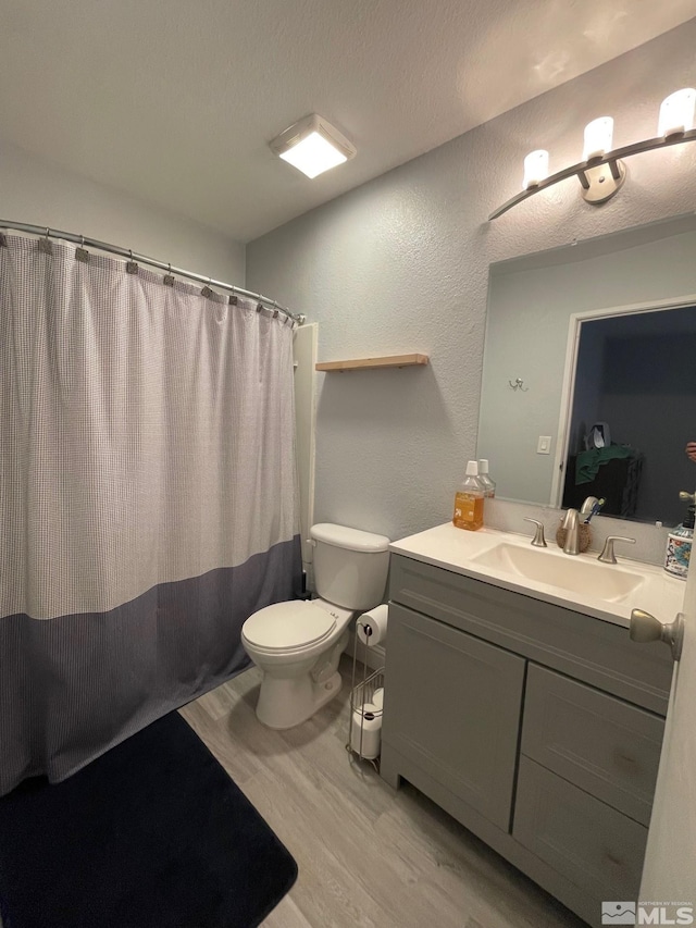 bathroom featuring wood-type flooring, vanity, and toilet