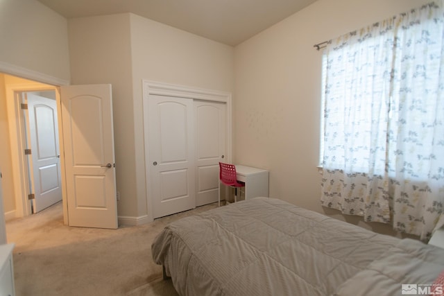 bedroom featuring light colored carpet and a closet