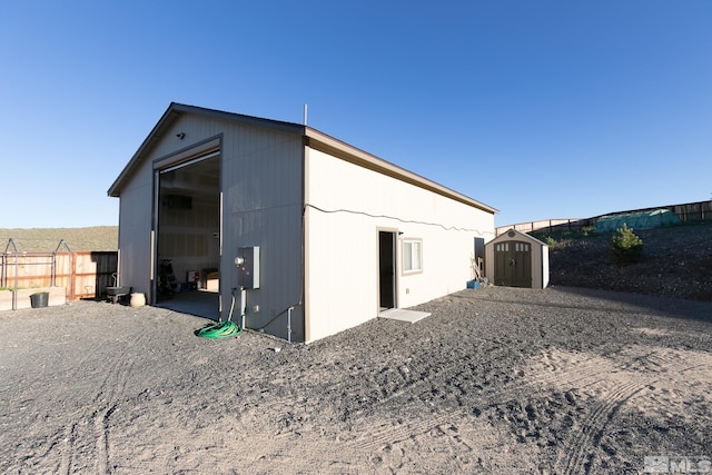 back of house with a shed