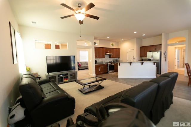 living room featuring ceiling fan and light wood-type flooring