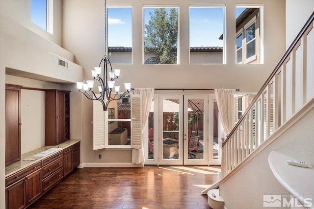 entrance foyer featuring a high ceiling, a chandelier, and dark hardwood / wood-style floors