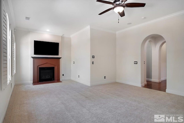 unfurnished living room featuring ornamental molding, carpet flooring, and ceiling fan