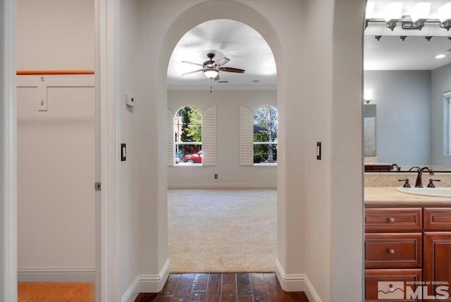 hall with sink and carpet