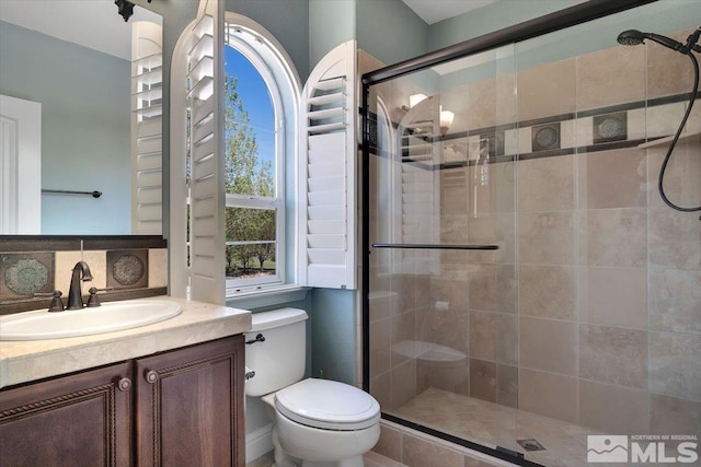 bathroom with a shower with shower door, backsplash, toilet, and vanity