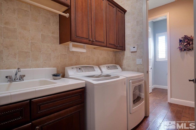 washroom featuring cabinets, dark hardwood / wood-style flooring, independent washer and dryer, and tile walls