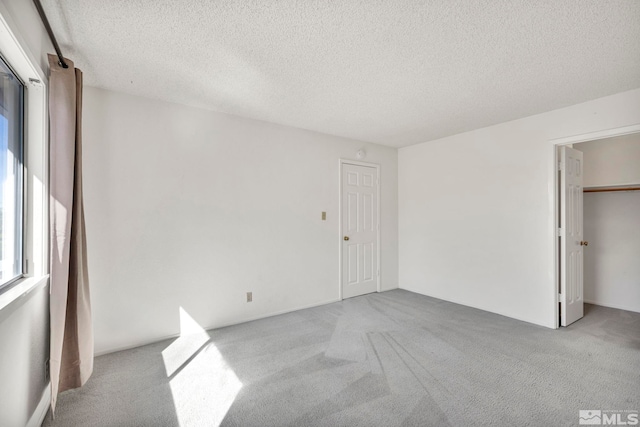 unfurnished bedroom featuring light colored carpet and a textured ceiling