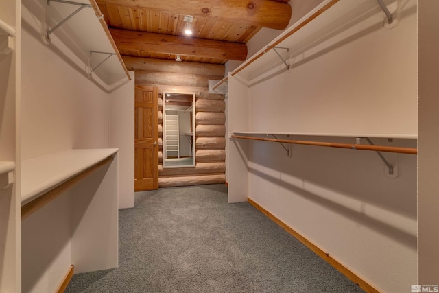 spacious closet with beam ceiling and carpet flooring