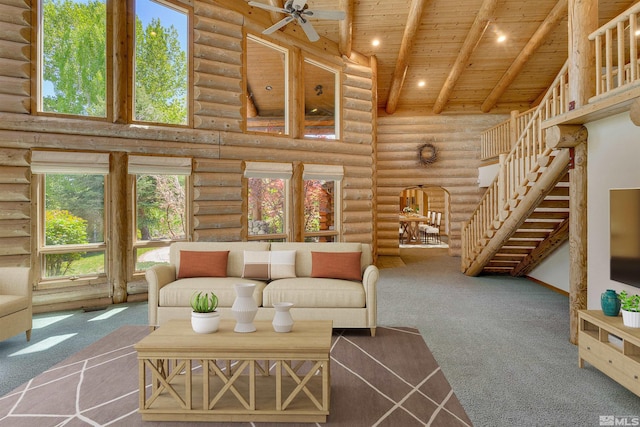 carpeted living room featuring wooden ceiling, log walls, beam ceiling, high vaulted ceiling, and ceiling fan