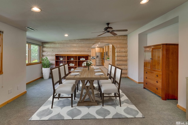 dining room with ceiling fan, carpet floors, lofted ceiling, and rustic walls