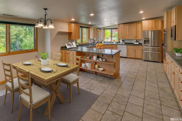 dining room featuring sink, an inviting chandelier, vaulted ceiling, and light tile floors