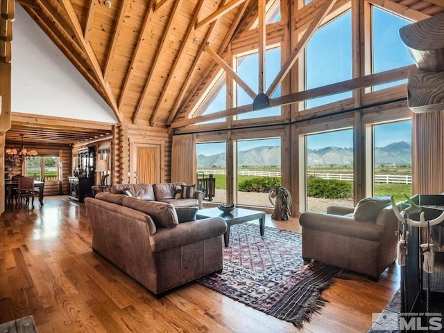 living room featuring high vaulted ceiling, a mountain view, and a healthy amount of sunlight