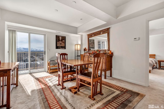 dining area featuring carpet flooring and a raised ceiling