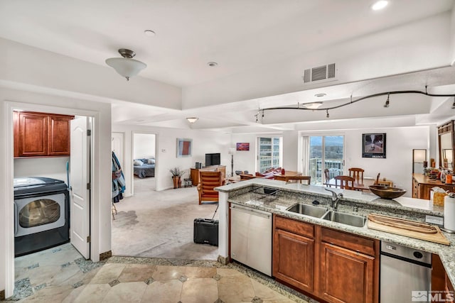 kitchen with light carpet, sink, stainless steel dishwasher, and washer / clothes dryer