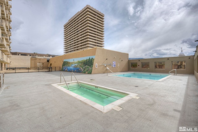 view of pool featuring a hot tub and a patio area