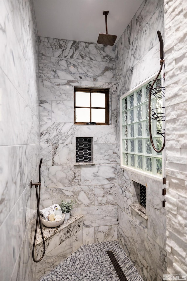 bathroom featuring tiled shower and plenty of natural light