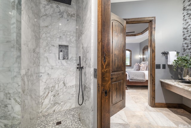 bathroom featuring a tray ceiling, a tile shower, and tile flooring