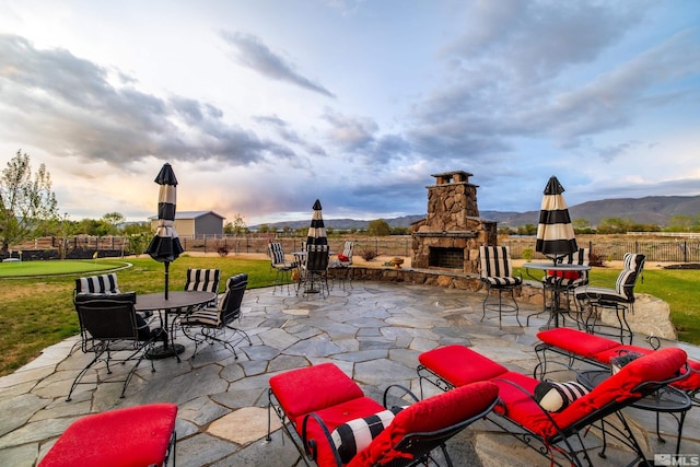 view of terrace featuring an outdoor stone fireplace