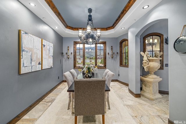 tiled dining space featuring a raised ceiling and a chandelier