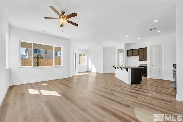 unfurnished living room featuring ceiling fan and light hardwood / wood-style flooring