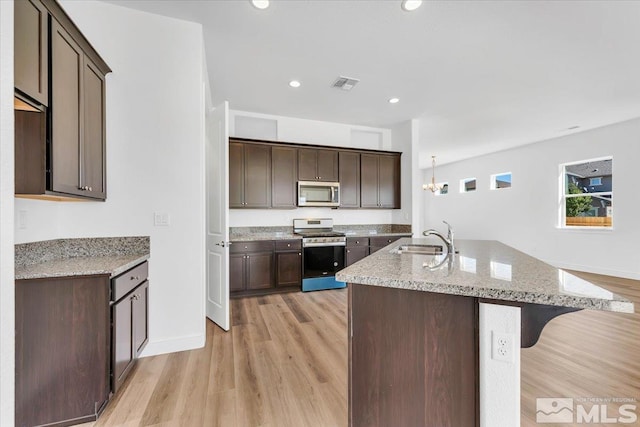 kitchen featuring light hardwood / wood-style flooring, appliances with stainless steel finishes, sink, and dark brown cabinetry