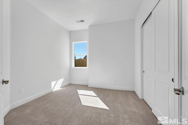 unfurnished bedroom with a closet and light carpet