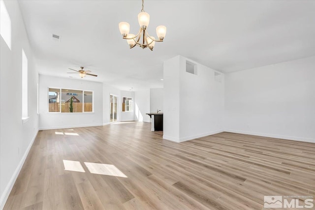 unfurnished living room featuring ceiling fan with notable chandelier and light wood-type flooring