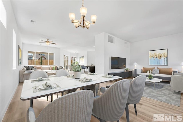 dining room featuring ceiling fan with notable chandelier and light wood-type flooring