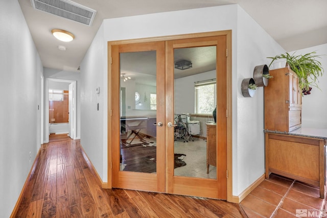 corridor with tile floors and french doors