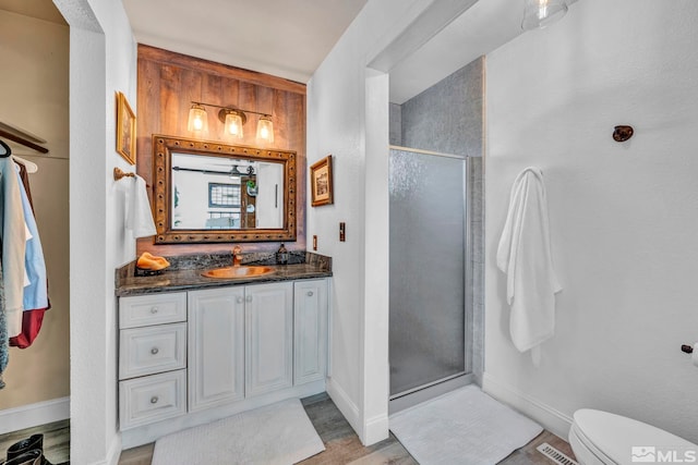 bathroom with an enclosed shower, hardwood / wood-style flooring, toilet, and vanity