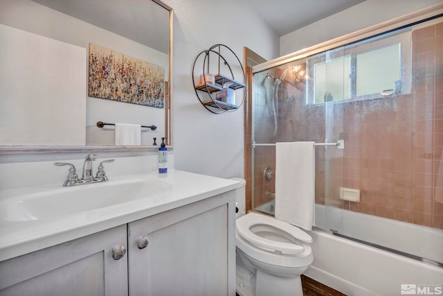 full bathroom with shower / bath combination with glass door, toilet, and vanity