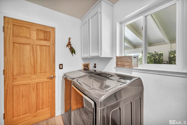 laundry area with washer and clothes dryer, cabinets, washer hookup, and light hardwood / wood-style floors