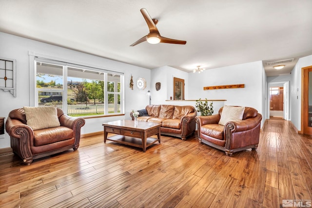 living room with wood-type flooring and ceiling fan