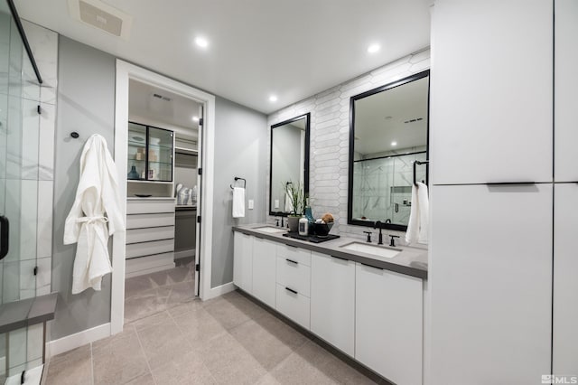 bathroom featuring walk in shower, dual sinks, tile flooring, and large vanity