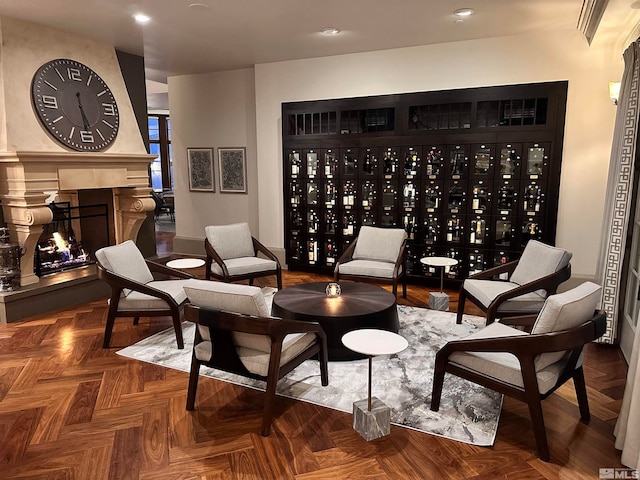 living area featuring a large fireplace and parquet flooring