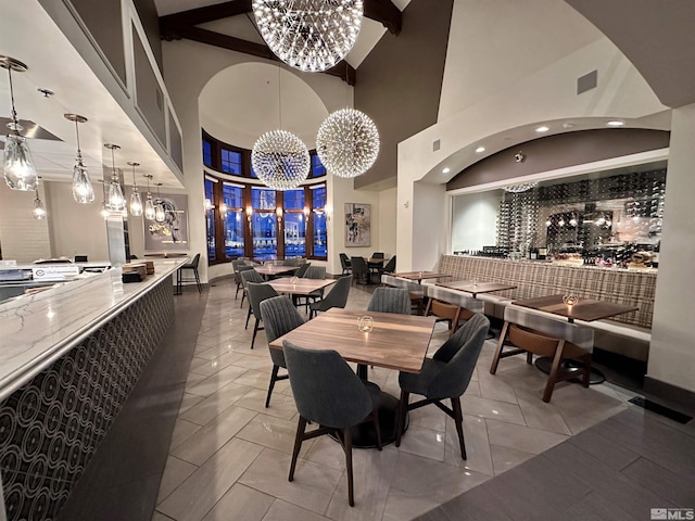 dining room featuring an inviting chandelier, a high ceiling, and tile floors