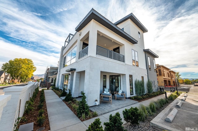 view of front of house with outdoor lounge area and a balcony