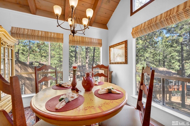 dining space with a notable chandelier, plenty of natural light, and vaulted ceiling with beams