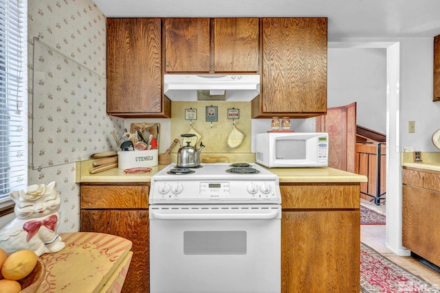 kitchen featuring white appliances and a wealth of natural light