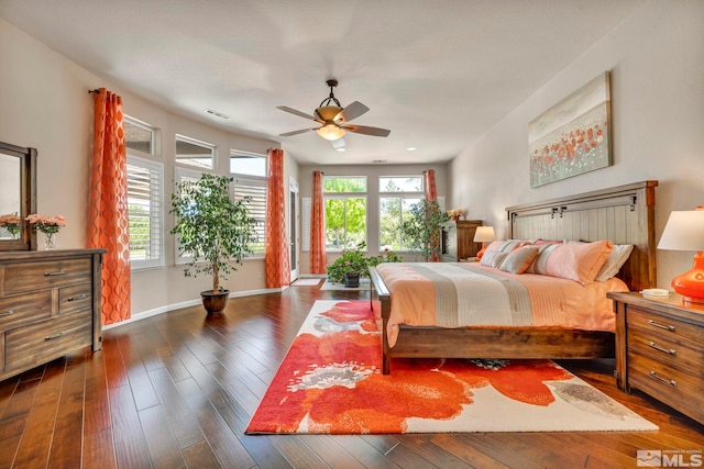 bedroom featuring dark hardwood / wood-style flooring, ceiling fan, and multiple windows