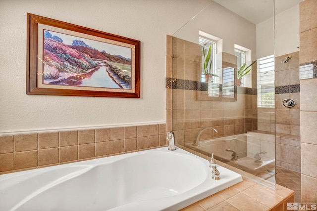 bathroom with shower with separate bathtub and a wealth of natural light