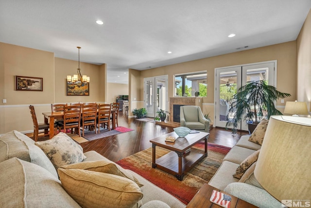 living room featuring an inviting chandelier, hardwood / wood-style flooring, and french doors